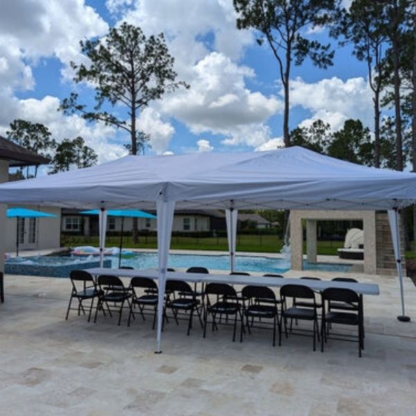 pool area of backyard with a tent and chairs