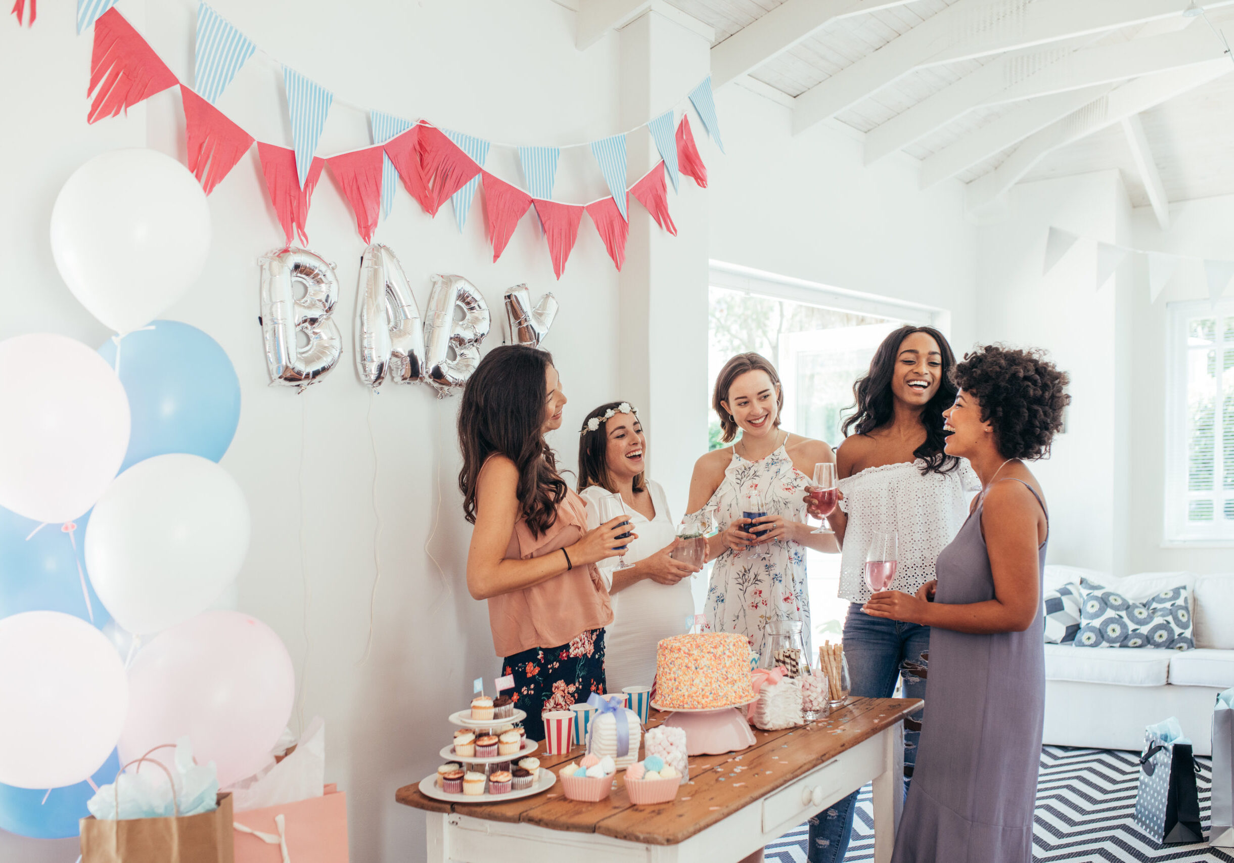 Baby shower. Group of diverse women together at baby shower. Smiling young pregnant woman celebrating baby shower with best friends.